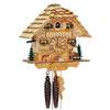 1-Day Natural Schneider Coo Coo Clock with a man chopping wood on the right. Logs sit underneath the dial in the middle with a German Shepherd Dog on the left. Two evergreen trees sit on each side of the house. Two windows with white curtains on the lower level and two above the balcony on the upper level. The cuckoo door is between the upper windows. The roof is made out of shingles.