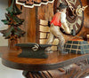 A blacksmith standing between an Anvil and a forge next to the dial of a Schneider cuckoo Clock