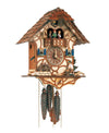 1-Day Schneider Chalet Coocoo clock with music. A man is chopping wood on the right and there is a waterwheel with a bench on the left. The house is white stucco with round timber. The dancers dance on a balcony above the dial. The cuckoo comes out from behind his door above the dancers under the shingled roof. 