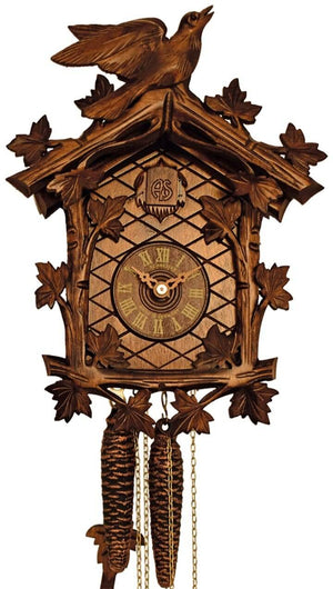 1-Day Schneider Traditional Coocoo clock without music. The face of the brown clock is crosshatched. There are carved ivy leaves growing delicately around the edge of the clock. The dial with Roman numerals sits in the middle, above it is the cuckoo door that opens when the cuckoo bird calls out the time on the full hour. There is a carved cuckoo bird on the top of the roof. He seems poised as if to take flight, with its beak half open.