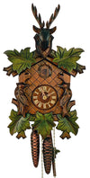 1-Day Schneider Traditional Black Forest Coocoo clock. The face of the brown clock is crosshatched. Carved green vine leaves are growing around the edge of the clock. Two birds on each side are facing the dial in the middle showing lighter colored Roman numerals and hands. The cuckoo door is carved with the initials “AS”. A large dark stained stag head with antlers sits on top of the crown.