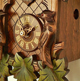 The Dial of a Schneider Black Forest Cuckoo Clock with roman numerals, Green Leaves and a carved Bird