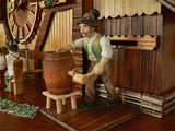 A Brewer in a green Jacket tapping a Keg at the Brauhaus on an Anton Schneider Chalet Cuckoo Clock 