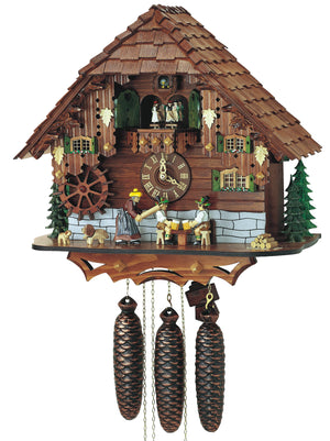 8-Day Black Forest Chalet coocoo clock with music. The base is a light wall of stone. And the rest of the clock is dark wood. Two men are sitting at a table drinking beer while a woman with a rolling pin is getting ready to hit the man on the left from behind. Two dogs, green trees and pile of cut logs complement the scene. The windows have green shutters and floral boxes and dancers spin on the balcony. The roof has shingles.