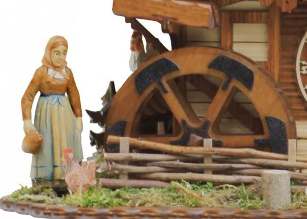 Close-up of a woman in traditional attire feeding chickens in front of a Black Forest farmhouse on the Rombach & Haas 8-Day Cuckoo Clock.