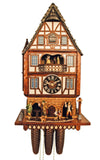 8-Day Schneider Chalet coocoo clock of a half-timbered stately town house. The lower part of the house looks like made of stone, the upper part is white with dark wood beams. There is a night watchman coming out of an arched door on the right guiding two children. Two men are on the left, one carries a rifle, greeting each other. The dancers spin on an ornately decorated balcony. The top floor of this tall, narrow house features the cuckoo door flanked by two windows. The shingled roof has little turrets.
