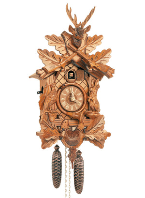 8-Day Black Forest Traditional Hunter’s coocoo clock. The clock features a rabbit on the right edge of the clock and a pheasant looking up on the left. The front face has diamond shaped gridlines, the dial has a hunter’s horn circled around it. Underneath the dial is a hunter’s pouch. Leaves decorate the corners of the clock and the top. Rifles are crossed on the top crown piece of the clock, above the cuckoo bird. Above the crossed rifles sits a prominent deer head with antlers.