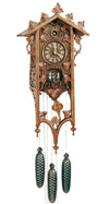 8-Day Schneider Railroad Station house coocoo clock with an elongated front. This very unusual elongated design where the edges of the clock frame extend downward underneath the clock box and are decorated with carved leaves and pointed ends. Carved leaves decorate the top, vine grows down the side. The dancers spin on a balcony below the dial, above it the cuckoo comes out from a circular opening. The sides of the clock box are decorated with a leaf design.
