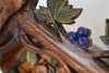 Painted dark blue Blueberries next to Ivy Vines and Leaves on a Traditional Schneider Cuckoo Clock