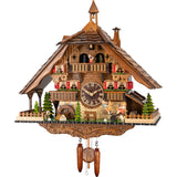 This hand-carved battery-operated Black Forest cuckoo clock features a boy and a girl on a teeter-totter on the right, watched over by a puppy dog. There is a bench underneath the clock dial, and a St. Bernard wearing a keg on the left by pine trees. The sides of the base platform and the front corners are fenced in. There are two balconies on either side of the clock dial and a wide balcony above the dial where the dancers spin to the music. A bell tower adorns the top of the shingled roof.