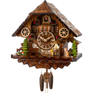 This hand-carved Black Forest cuckoo clock is a classic design which features decorative green pine trees on each corner, a grazing deer on the left and a moving wood chopper on the right who is watched over by his trusty St. Bernard. Each side of the balcony is adorned by a wagon wheel. A cuckoo bird pops out from behind his door above the balcony to announce the time on the full hour. A perfect addition to any home.