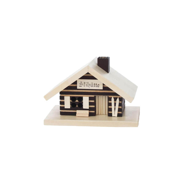 This smoker house looks like a German ski hut. Built out of black and white wood with a white roof and a pair of skis next to the door. There are four holes in the window and the chimney on the roof to let the smoke through. You can lift off the house from the base to put the incense cone on a metal base  inside the house.