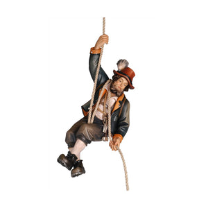 Carved wooden statue of a mountain climber, in traditional German mountain climber clothing and hat, holding a climbing rope.