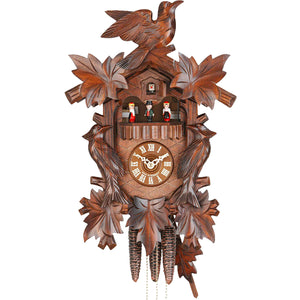 Ornate carved Leaves and Birds frame the Dial and Black Forest Dancers on a Hekas Traditional Cuckoo Clock