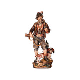 Carved wooden statue of an alpine hunter, smoking a pipe and holding a rifle, with a dachshund by his feet.
