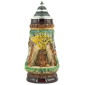 King Beer Stein with a cozy brown bear who sits in a grotto on a stone and observes its environment. The brown and green tones of the Mug underline the nature scenes.
