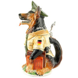 Beer stein in the shape of a police dog. The shepherd dog wears a typical green German police uniform and holds a stack of books in his paw. In the side view you can see a pocket for handcuffs and the German flag on his arm