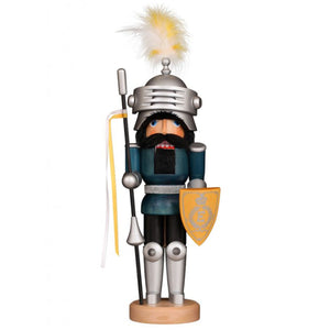 Handcrafted German nutcracker of Sir Lancelot in silver armor, holding a lance with yellow and white ribbons, a matching shield, and a feathered helmet.