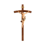 Carved wooden crucifix, depicting the body of Christ in a style reminiscent of Leonardo Da Vinci, painted in a variety of colors with gold accents.