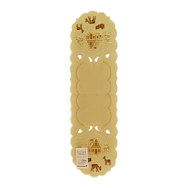 Cream color table runner, with a wavy stitching design in the center, and on either end there are cutouts and a scene of a snowy chalet in the forest, surrounded by deer.
