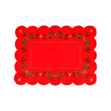 Rectangular red table runner with scalloped edges. The interior border is a line of gold stitching, while the outer border is a pattern of floral arrangements and holly, and a golden star in each corner.