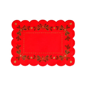 Rectangular red table runner with scalloped edges. The interior border is a line of gold stitching, while the outer border is a pattern of floral arrangements and holly, and a golden star in each corner.