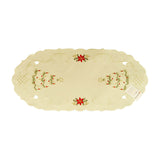 White table runner with Christmas trees, filigree, and cutouts on either end, and floral arrangements on the ends of the center.