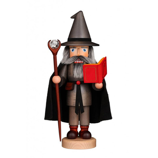 Handcrafted German nutcracker of Merlin the Wizard with a gray robe, pointed hat, red spellbook, and a staff topped with a crystal ball.
