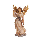 The standing angel carved out of wood is wearing an off-white dress with a bow in the front. The angel is holding a banner inscribed with the words “Gloria In Excelsis Deo”. She stands on a cloud-like base and her ornately carved wings are painted in a shiny golden color.