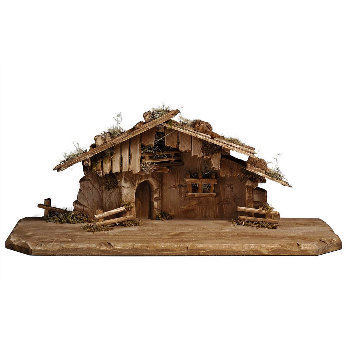 The wooden stable made of Sycamore maple features a roughly hewn base for the figurines of the nativity set. There are split-rail fence sections on both sides of the stable and a third fence sits on the back left corner. A rounded door at an angle on the left front leads to the inside of the wooded stable made of sycamore maple. The upper story underneath the roof is a hay storage and covered with boards. The roofline is rather flat and features stones and dried moss. 