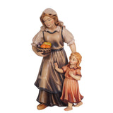 A shepherdess wearing a dress with a collared blouse underneath is holding a basket with fruits in her right hand. She also has a head overing over her long hair. A little girl with a short sleeved-dress featuring flowers at the bottom is by her left side. The mom’s left hand is guiding the girls back, the girl’s right hand is stretched out and holding on to her Mom’s dress. 