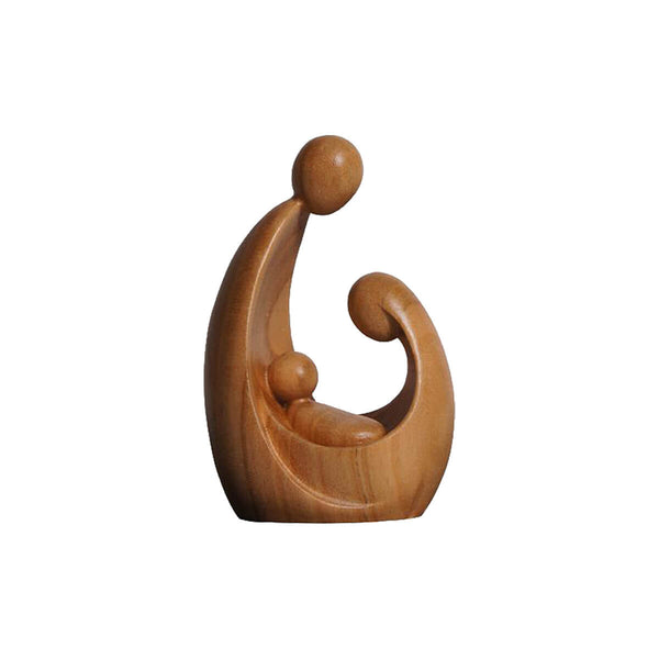 Carved wooden statue of a stylized modern design of Mary and Joseph looking upon Jesus, cradled in Mary's arms.