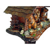 Side of a Schwer Cuckoo Clock with a Bench under a Fir Tree next to a stack of Wood and two Bears