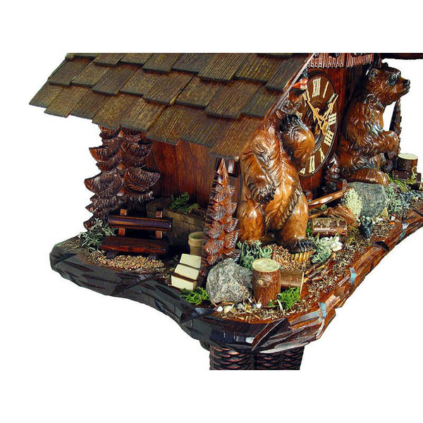 Side of a Schwer Cuckoo Clock with a Bench under a Fir Tree next to a stack of Wood and two Bears