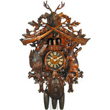 8-Day traditional Black Forest hunter style coocoo clock. The dark stained solid wood clock features a hunted rabbit and pheasant on each side, framed against a continuing trim pattern of woodland leaves and ivy. A hunting horn encircles the clock’s dial, while a powder pouch hangs at the bottom of the base. Above the dial, the dancers spin to the music on a carved balcony. The top features crossed rifles, ivy growing on the trim and a stag head.