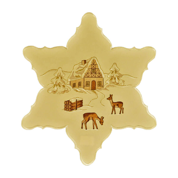 Star shaped cream color table linen, with a center design of a snow-covered chalet and trees, deer, and a bundle of wood.