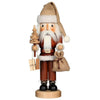 Christian Ulbricht Santa Nutcracker in subtle wood colors wearing a jute hat with white fur trim on his head. In his hands he holds a fir tree with gifts and a bulging jute sack.