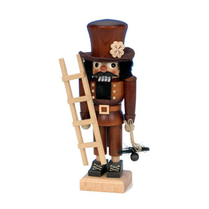 Ulbricht nutcracker chimney sweep in natural colors, holding a ladder in one hand, and a brush in the other, and wearing a top hat with a shamrock on it.