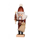 Santa Claus nutcracker in natural colors, holding a miniature tree in one hand, and a bag of toys in the other.