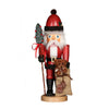 Santa Claus nutcracker, holding a bag of toys with a teddy bear, and a miniature tree atop a stick with the other.