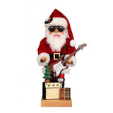 This Modern Santa Claus has a red coat with a red hat on. The white fur on the edges of the jacket and the hat matches perfectly with his white beard. With the dark sunglasses and the electric guitar he competes with every rock star. A small Christmas tree stands on the amplifier and a small gift is waiting to be opened.