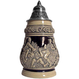 KING Beer Stein with three young men sitting on beer kegs drinking beer from Mugs. While one of them smokes a long pipe, the other two are fooling around. This Stein has both a richly decorated rim and a detailed Pewter Lid.